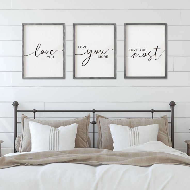 three framed art prints on the wall above a bed