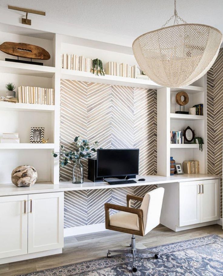 a home office with white shelves and shelving units, including a computer on the desk