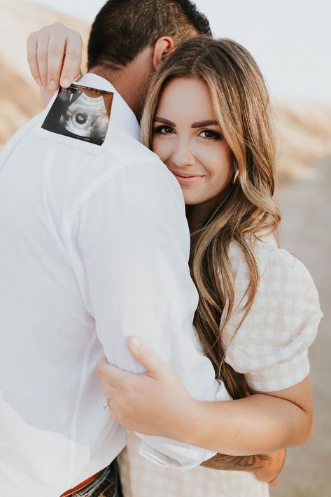 a man and woman hugging each other in the desert