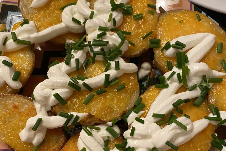 a plate filled with potato wedges covered in sour cream