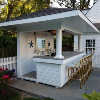 an outdoor kitchen with bar seating and chairs