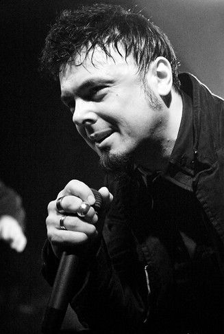 a black and white photo of a man holding a microphone