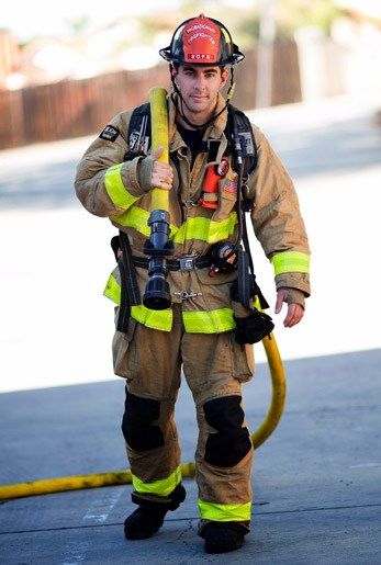 a firefighter is walking with his hose