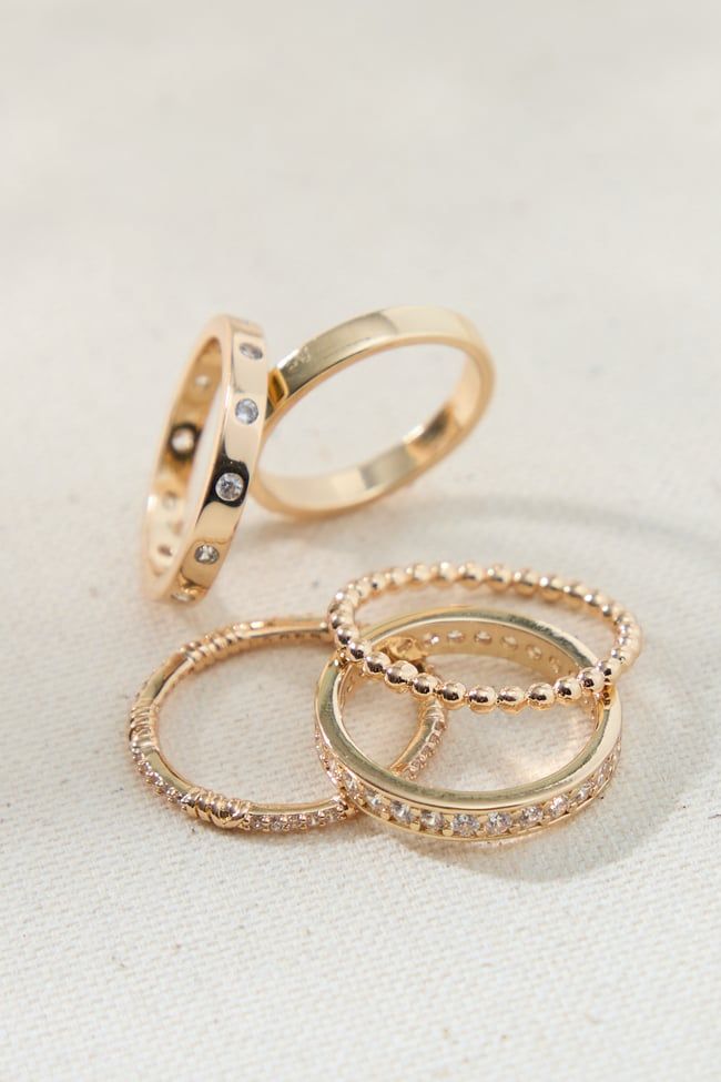 The set offers a variety of rings, allowing you to mix and match, stack them together, or wear them individually. The classic gold band design ensures a timeless look that transcends trends. However, the sparkling crystals add a touch of modern flair, keeping the rings relevant and stylish for any occasion. Ring Sets Aesthetic, Simple Ring Stack, Simple Rings Everyday Casual, Gold Rings Aesthetic, Dainty Ring Stack, Gold Rings Set, Simple Gold Band, Rings Stack, Simple Stacking Rings