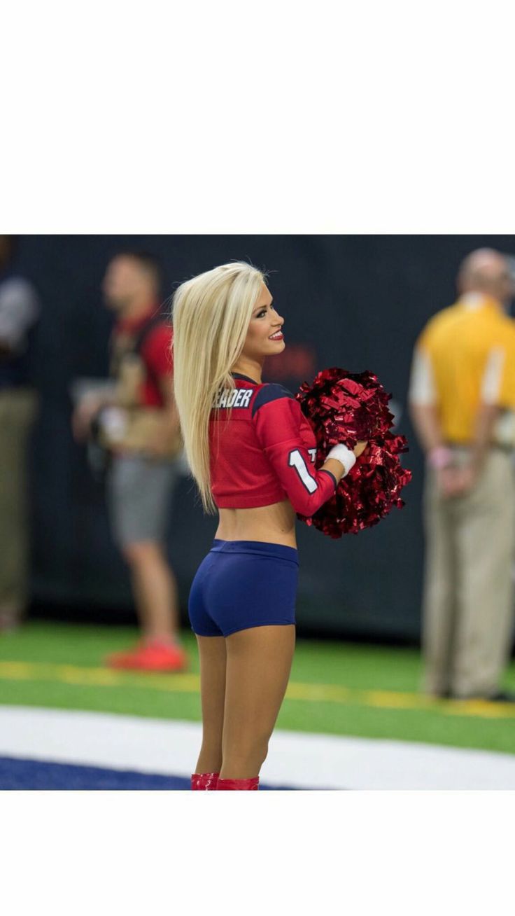 a cheerleader is standing on the sidelines with her pom - poms