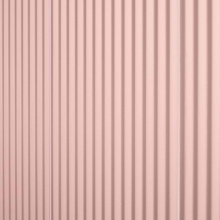 the side of a pink metal building with vertical slats