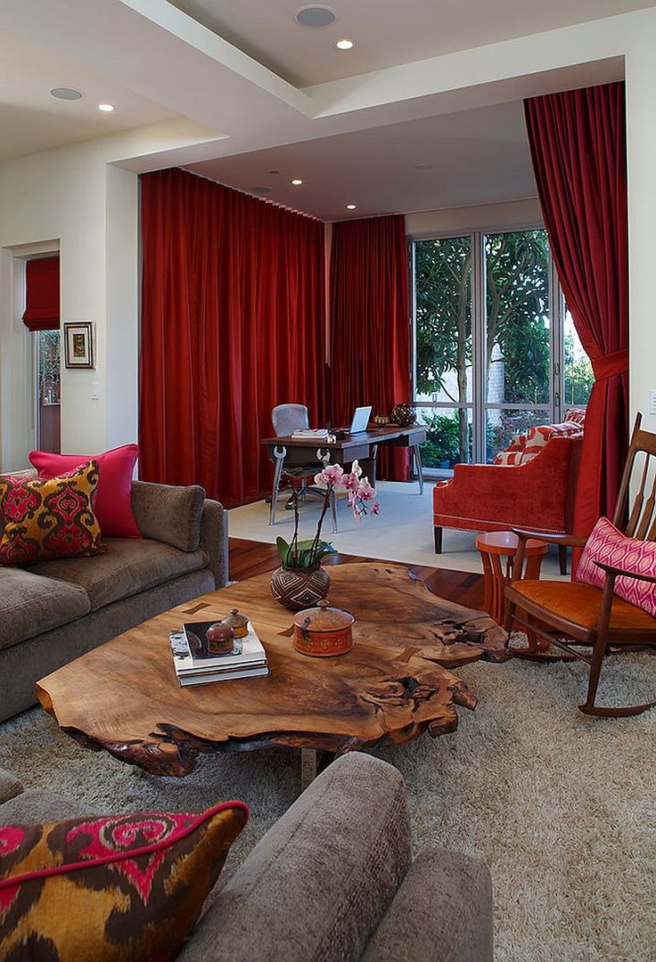 a living room filled with furniture and red curtains