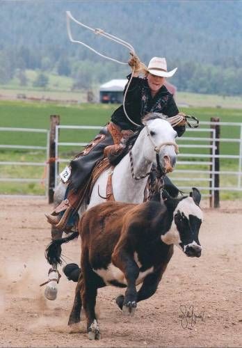 a man riding on the back of a white horse next to a brown and black cow