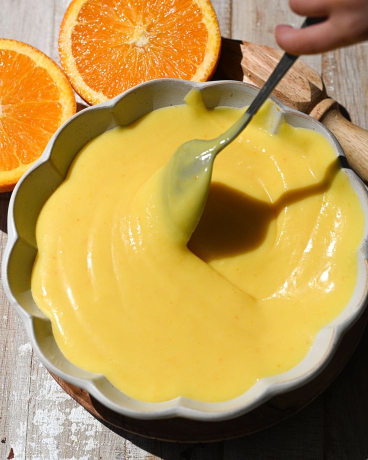 a spoon in a bowl filled with orange sauce