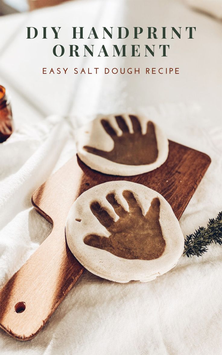 two handprinted dishes sitting on top of a wooden cutting board