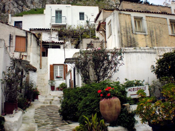 an alleyway with steps leading up to buildings and flowers growing on the side of it