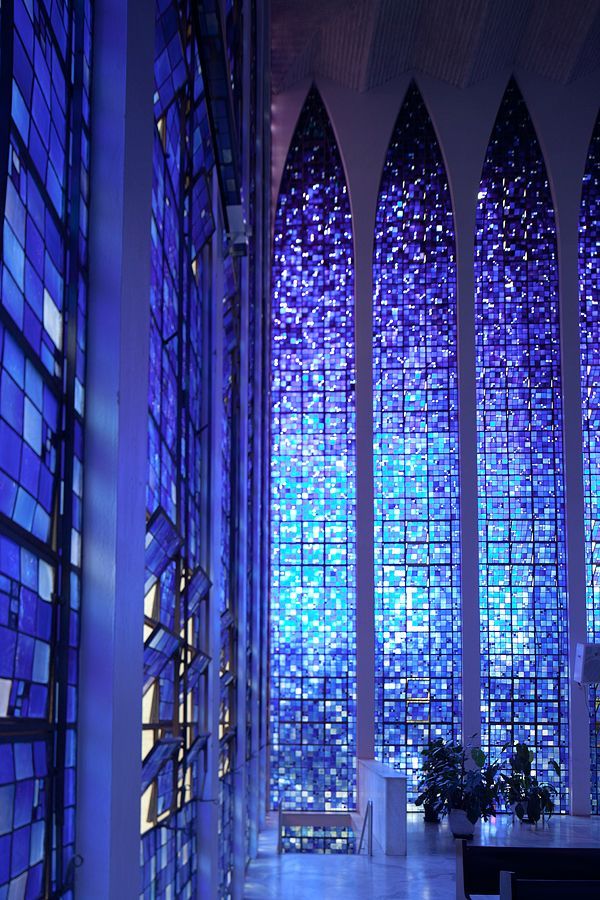 the inside of a church with stained glass windows and blue lights on it's walls