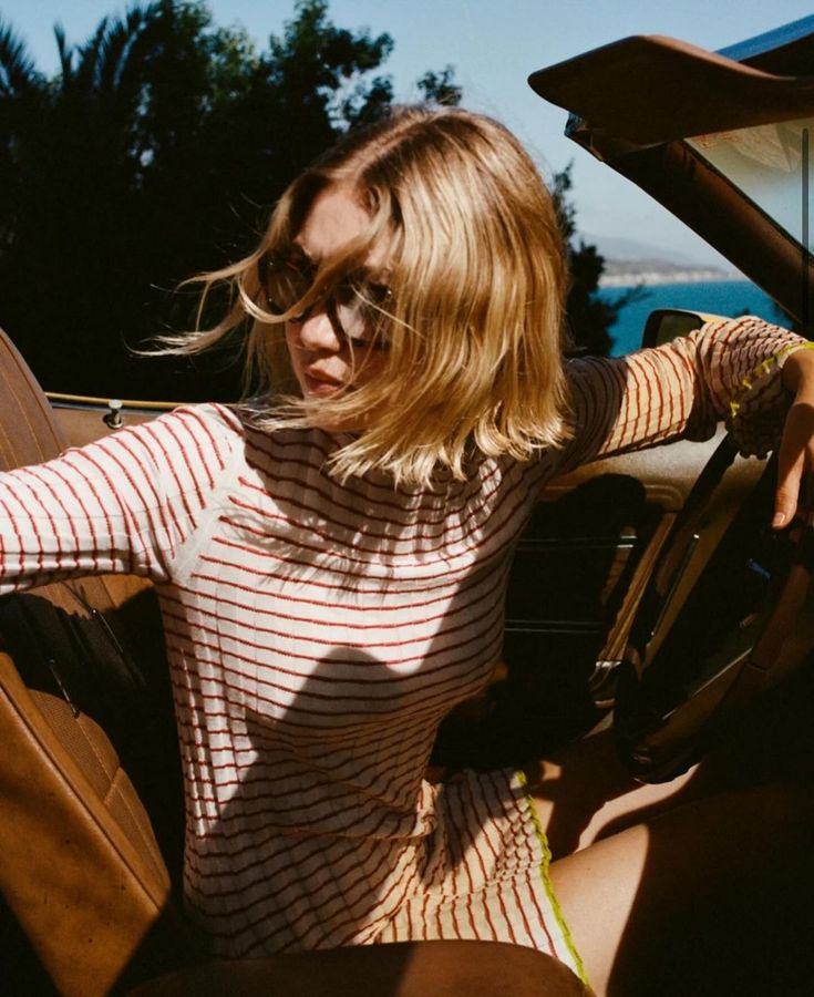 a woman sitting in the driver's seat of a car