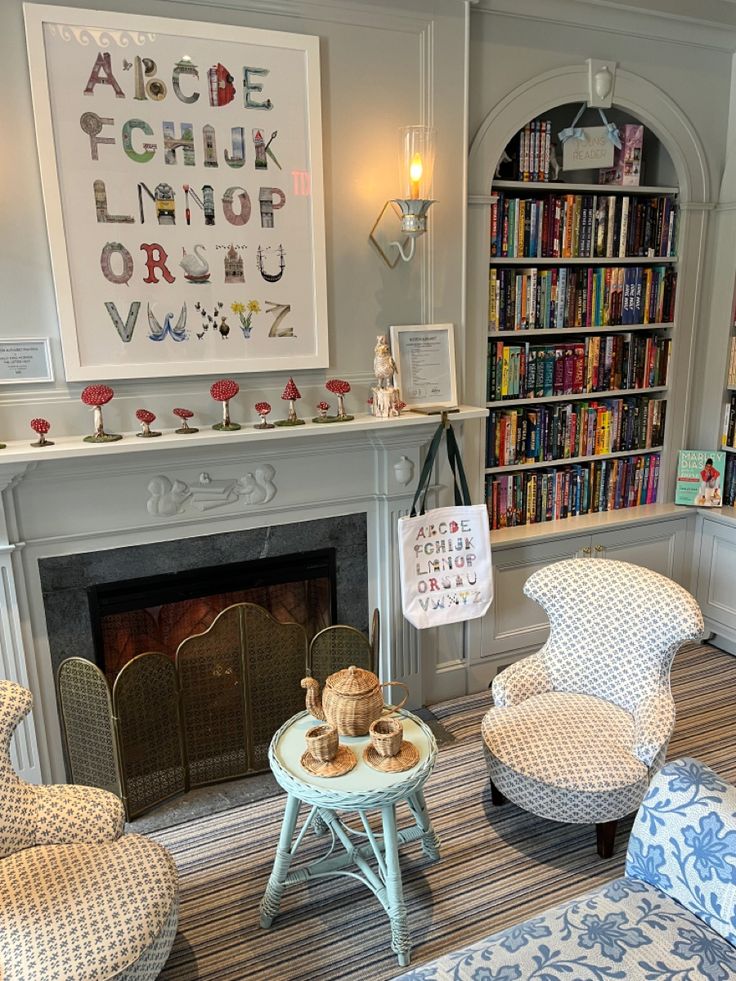 a living room filled with furniture and a fire place in front of a book shelf