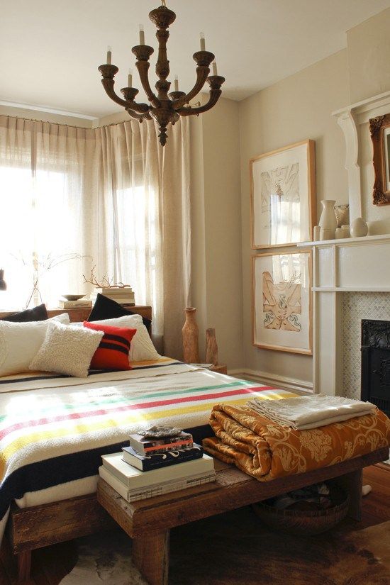 a bedroom with a large bed and a chandelier hanging from it's ceiling