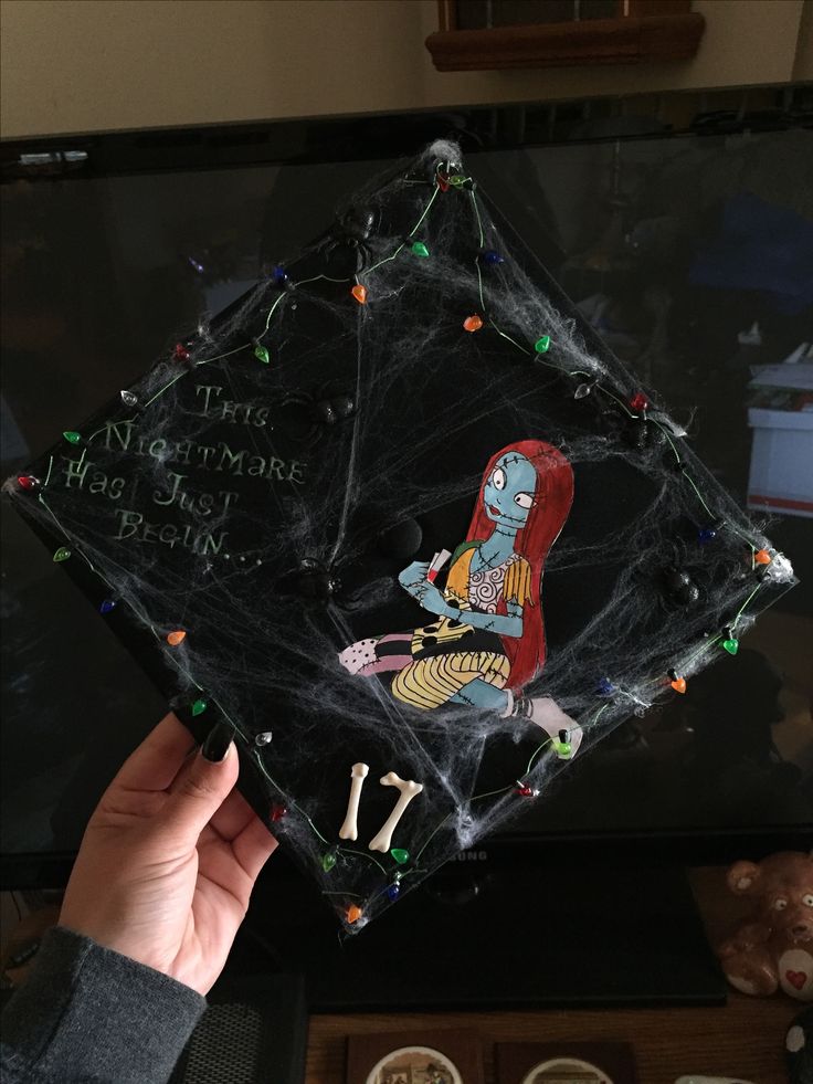 someone holding up a halloween decoration in front of a tv