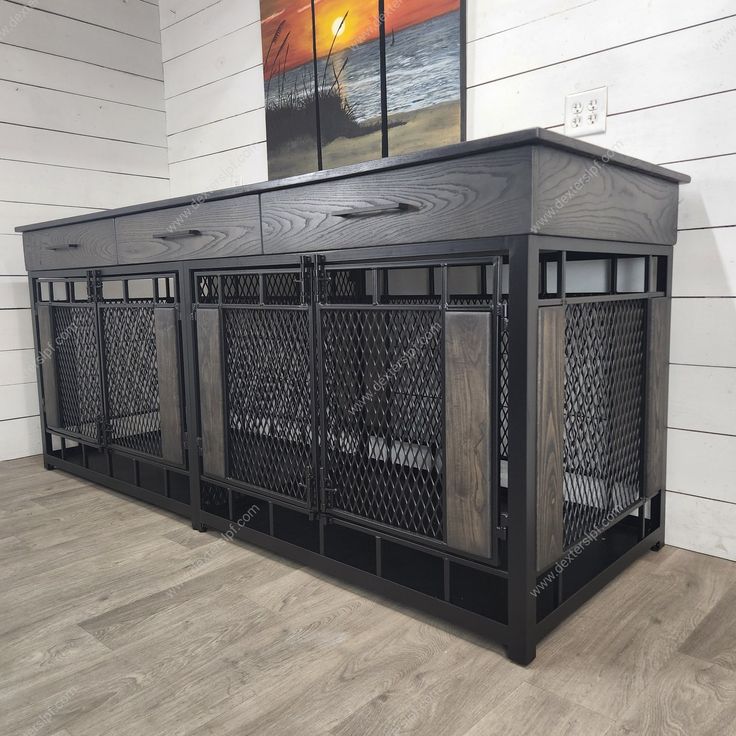 a large black metal cabinet sitting on top of a wooden floor next to a painting