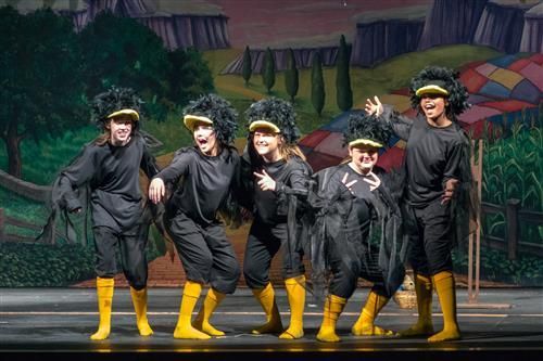 a group of people standing on top of a stage wearing rain boots and rubber boots