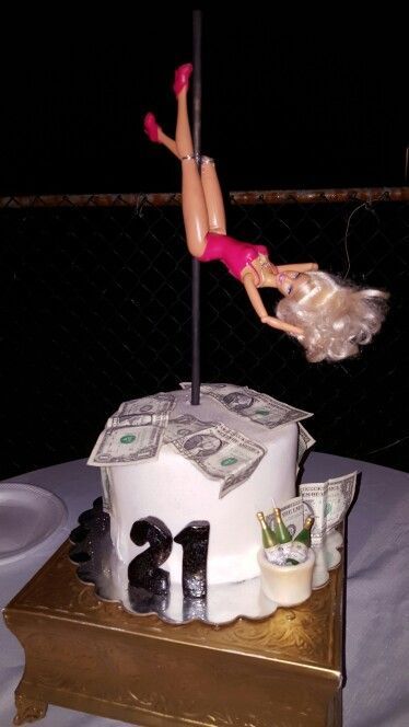 a cake that has a doll on top of it with money in the air above it