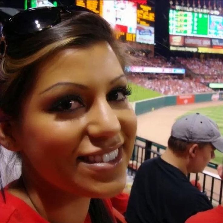 a woman is taking a selfie at a baseball game