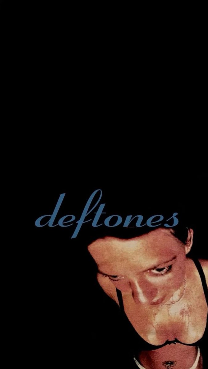 a man in a black shirt and tie with the words deftones written on it