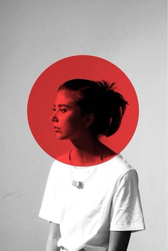 a woman standing in front of a red circle over her head, with the image of a person's face on it