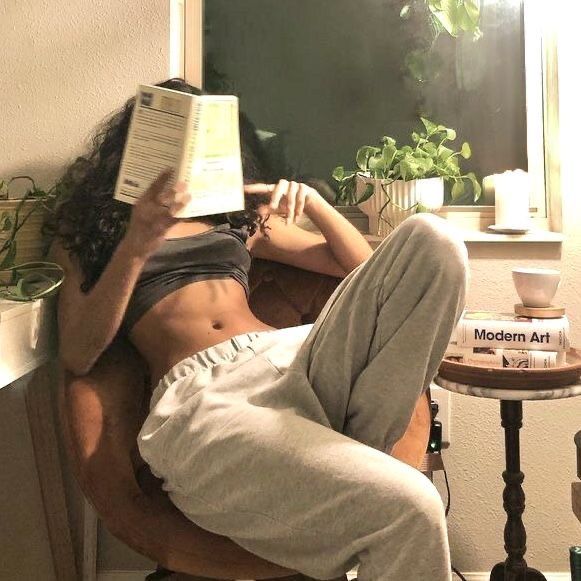 a woman reading a book while sitting in a chair