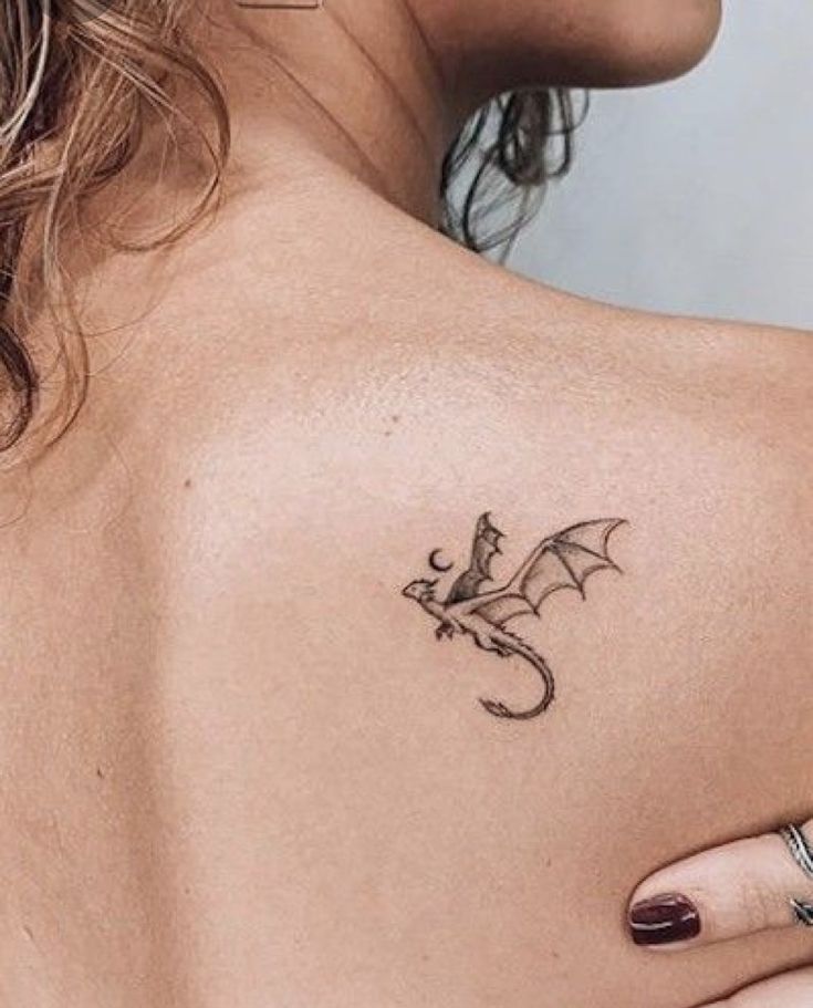 a woman with a dragon tattoo on her back