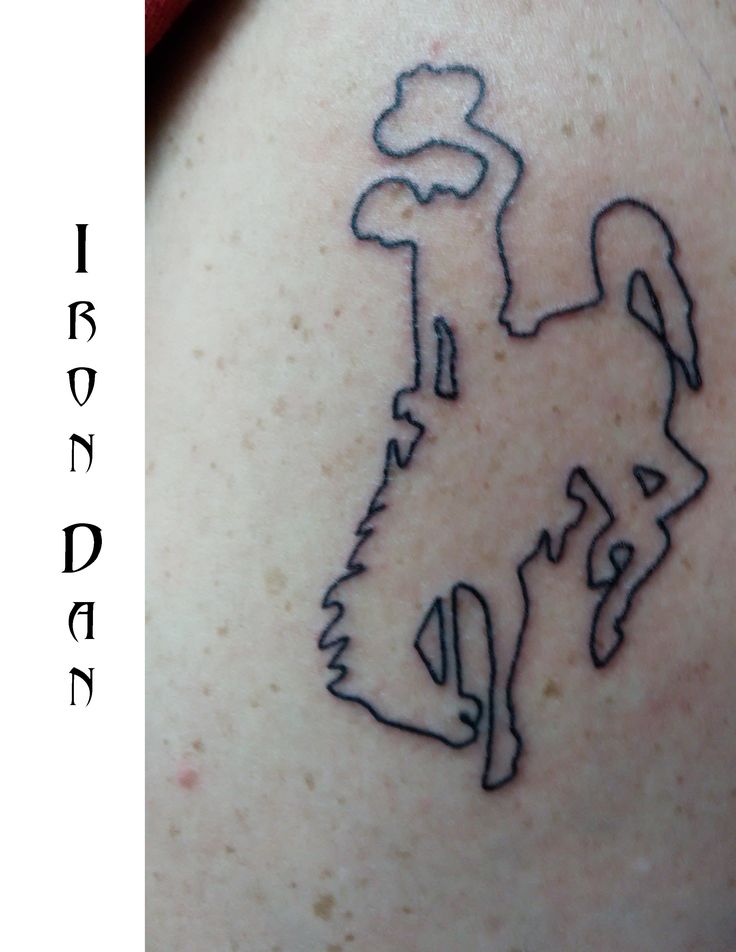 a tattoo on the back of a woman's shoulder with an image of a dog