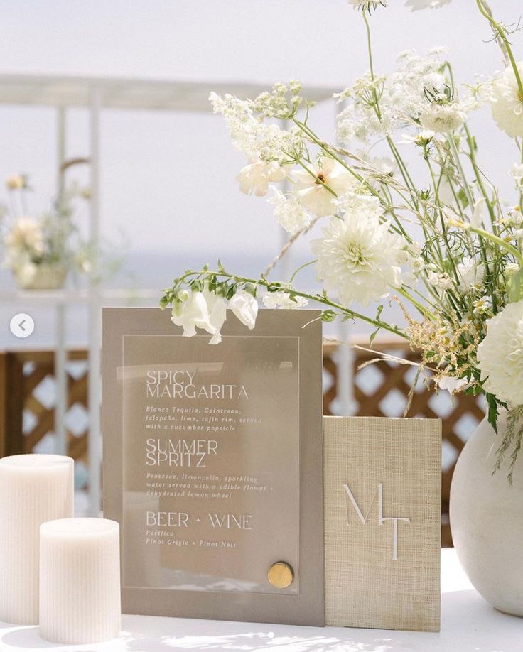 a table topped with white flowers and candles