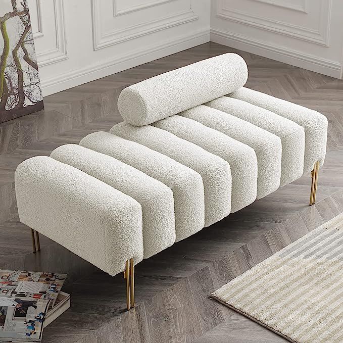 a white couch sitting on top of a wooden floor next to a rug and magazine rack