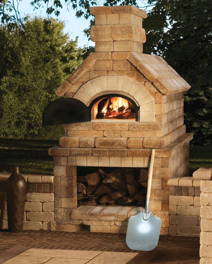 an outdoor fireplace with a shovel in front of it