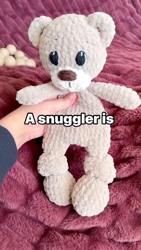 a hand holding a white teddy bear on top of a purple bed sheet with the caption, a smugler's