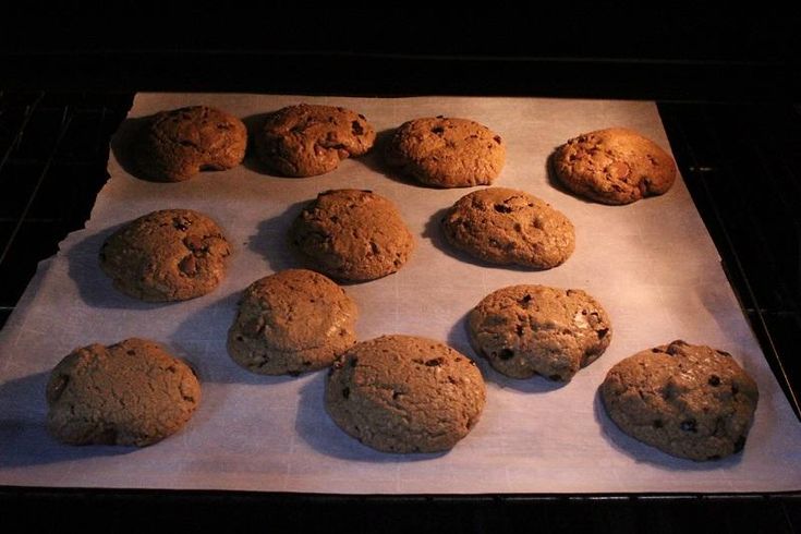 twelve chocolate chip cookies sitting on top of a baking sheet in an oven, ready to be baked