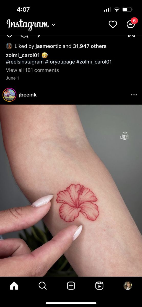 a woman's arm with a red flower tattoo on the left side of her arm