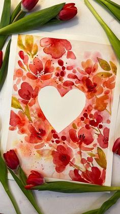 a card with a heart surrounded by red flowers