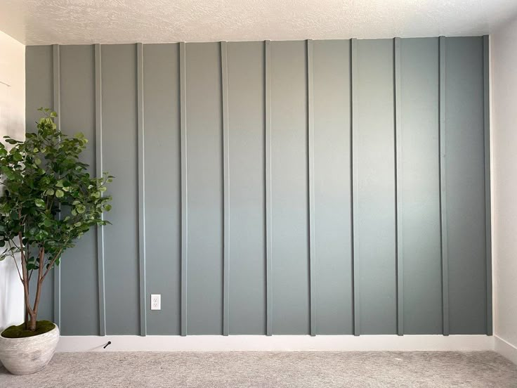 a potted plant sitting in front of a wall with vertical striped panels on it