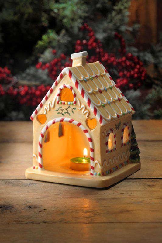 a small gingerbread house candle holder on a table