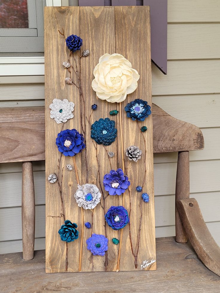 a wooden sign with flowers on it