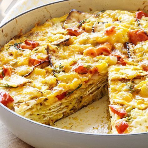 an omelet in a pan with one slice cut out and ready to be eaten