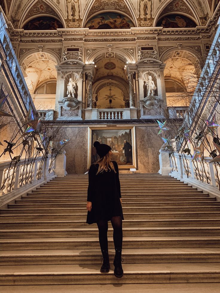 a woman standing at the top of some stairs