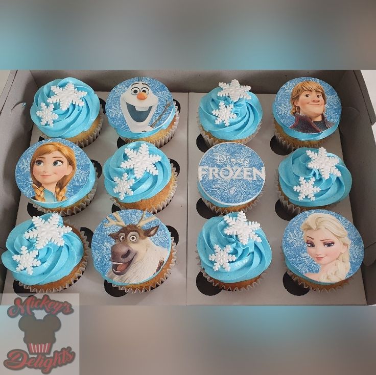 cupcakes decorated with frosting and images of frozen princesses are in a box