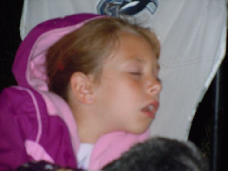 a young child sleeping in a car seat