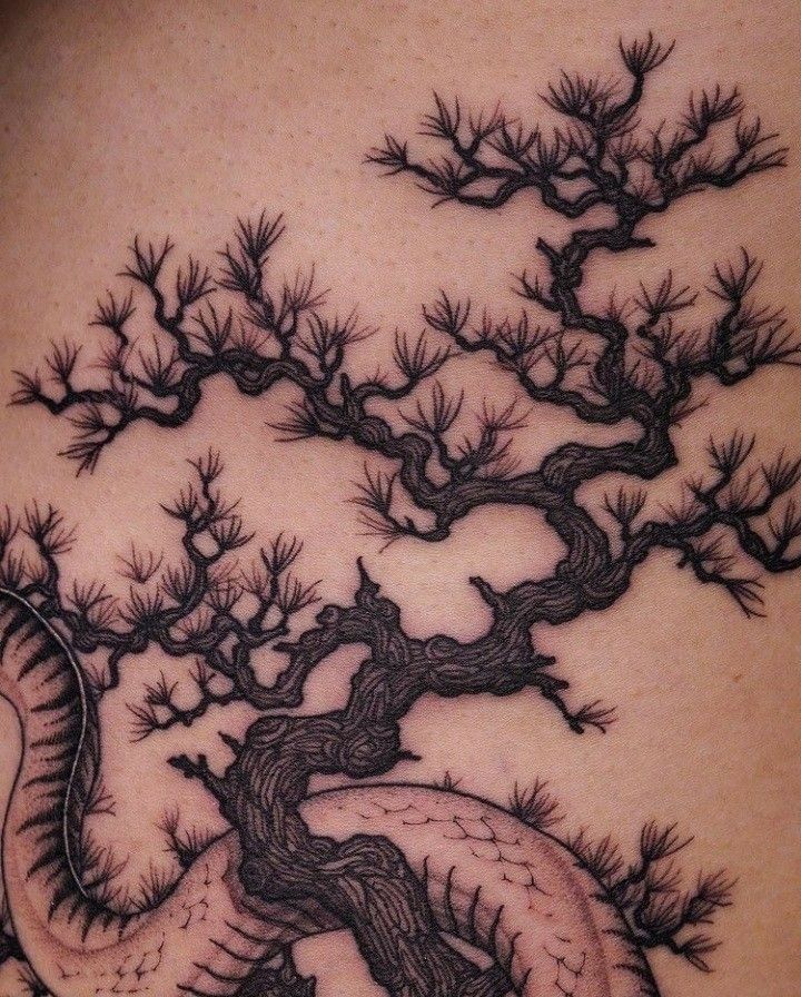 a tattoo with a tree and a snake on it