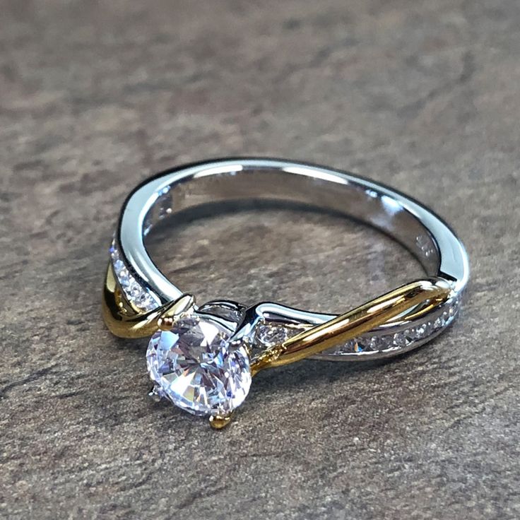 a white and yellow gold engagement ring with diamonds on it's sidestrap