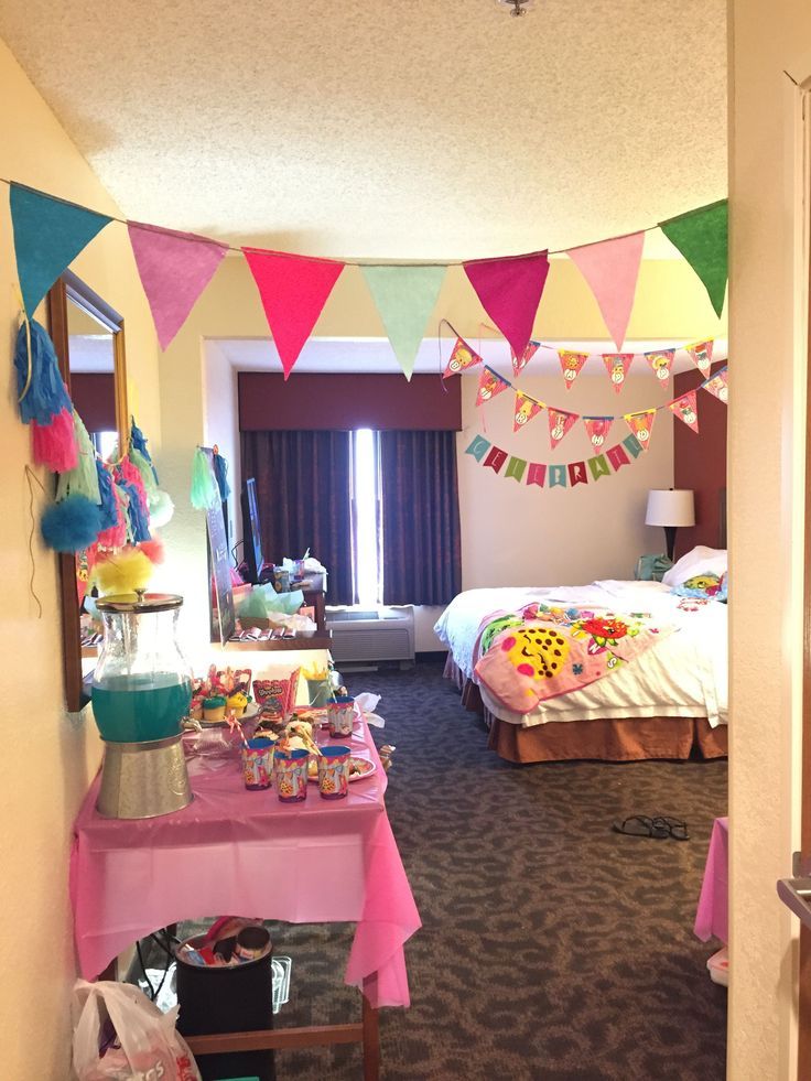 a room filled with lots of colorful flags and decorations on the wall next to a bed