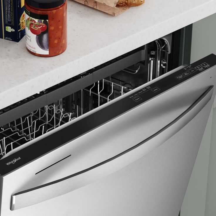 an open dishwasher sitting on top of a counter