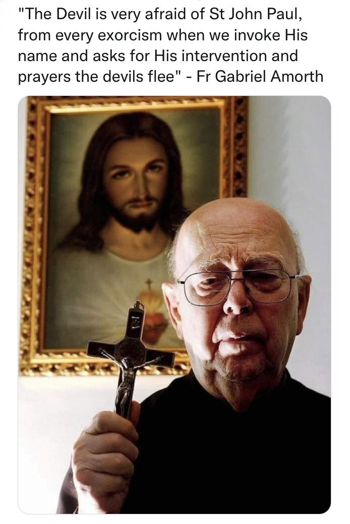 an old man holding a cross in front of a painting