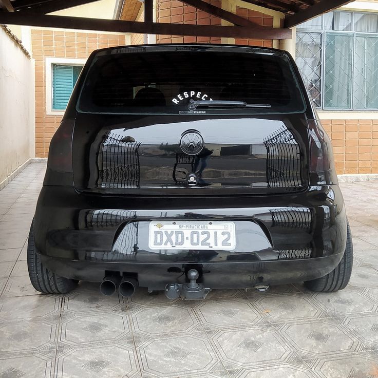 the back end of a black car parked in a garage