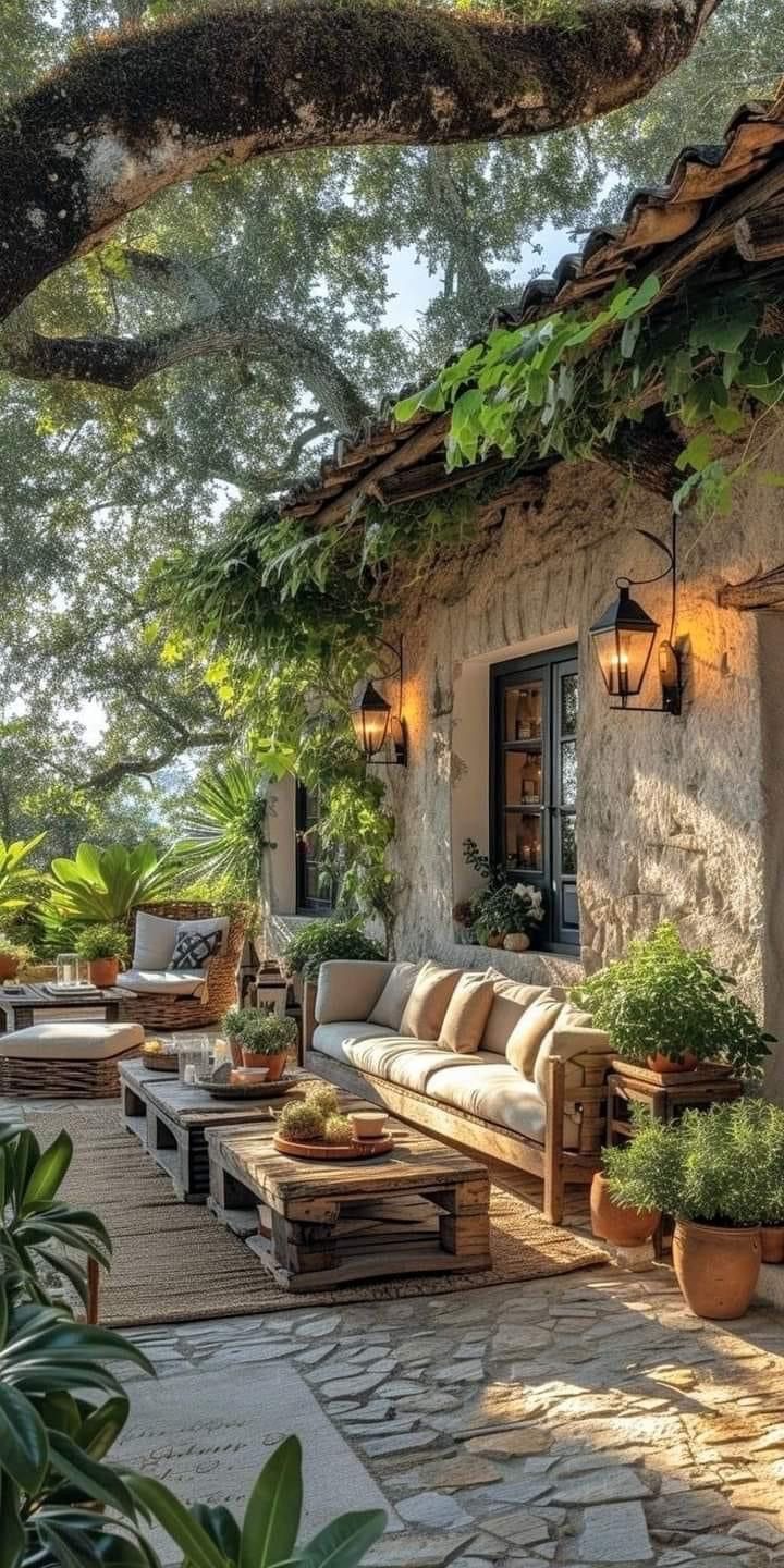 an outdoor living area with couches and potted plants